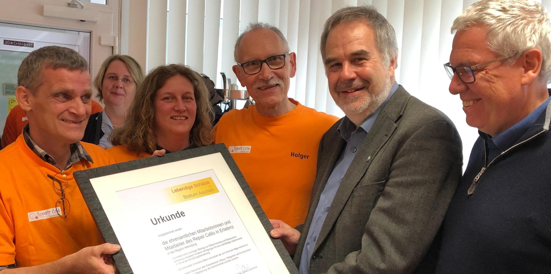 Pfr. Rolf-Peter Cremer (2.v.r.), Leiter der Hauptabteilung Pastorl / Schule / Bildung, und Dieter Spoo (r), Diözesanrat der Katholiken, übergaben die Urkunde an die Ehrenamtlichen des Repair Cafés.